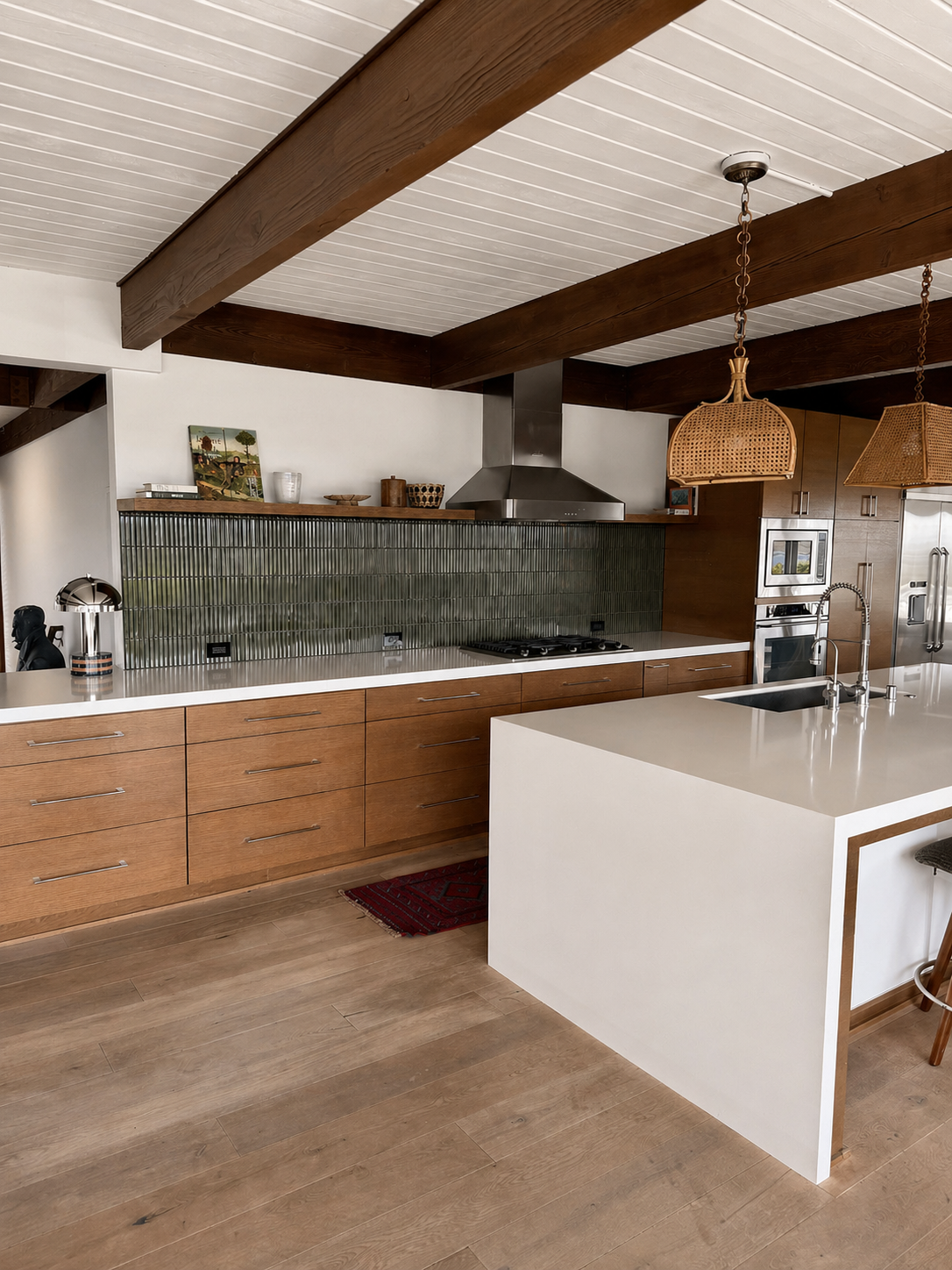 Wide-angle view of a remodeled kitchen with green tile backsplash, rattan pendant, and a center island