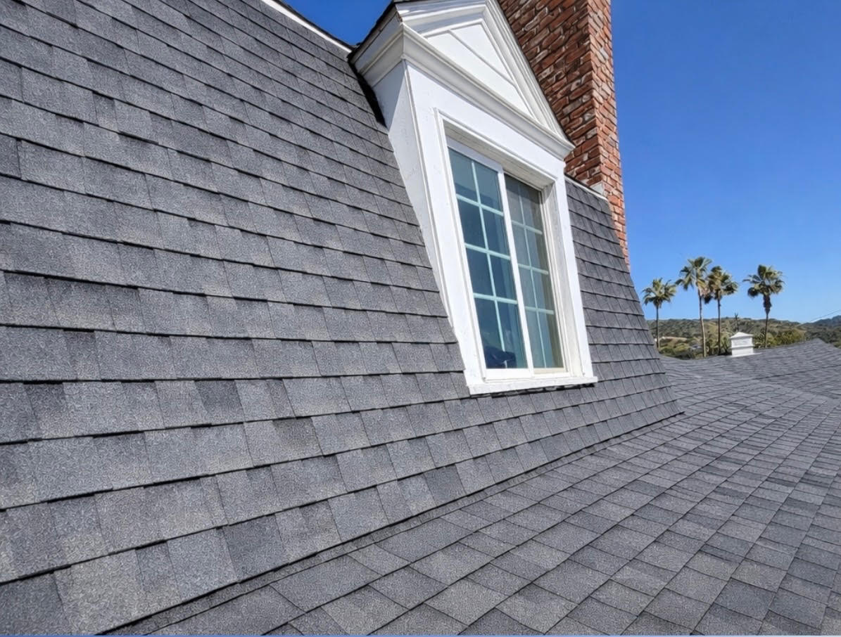 Shingle roof field with a dormer window and a brick chimney
