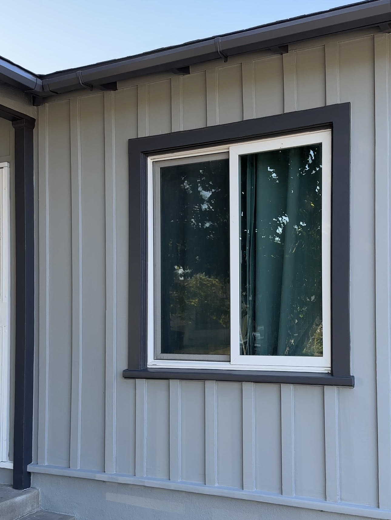 Modern home exterior with a new picture window set into board-and-batten siding